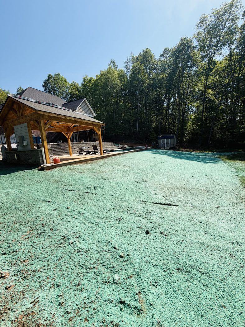 Residential backyard with pavilion and freshly hydroseeded lawn